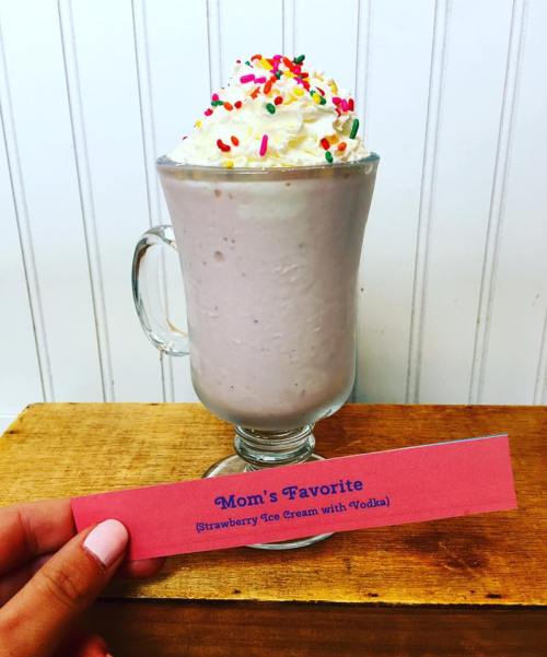 A glass of strawberry ice cream topped with whipped cream and sprinkles, labeled "Mom's Favorite (Strawberry Ice Cream with Vodka)."
