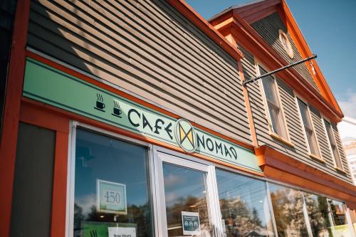 Exterior of a café named "Café Noma," featuring a colorful sign and a charming building facade.