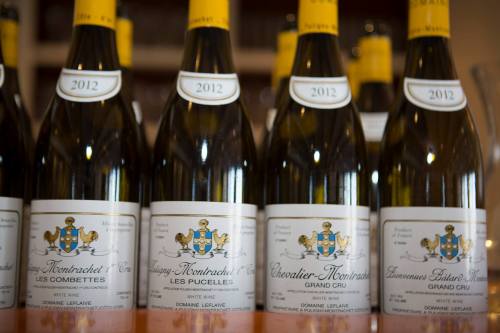 A row of wine bottles labeled with "Puligny-Montrachet," "Chevalier-Montrachet," and "Bâtard-Montrachet," vintage 2012.