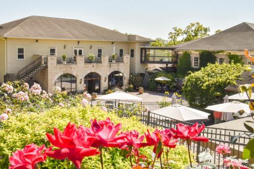 A scenic view of a building surrounded by blooming flowers and outdoor seating areas on a sunny day.