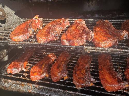 Grilled meat sizzling on a barbecue rack, showcasing a rich, smoky glaze and appetizing texture.