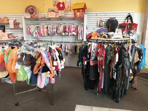 A colorful display of children's clothing on racks in a store, featuring various outfits and accessories.
