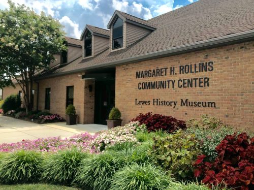 Exterior of the Margaret H. Rollins Community Center and Lewes History Museum, featuring flowers and greenery.