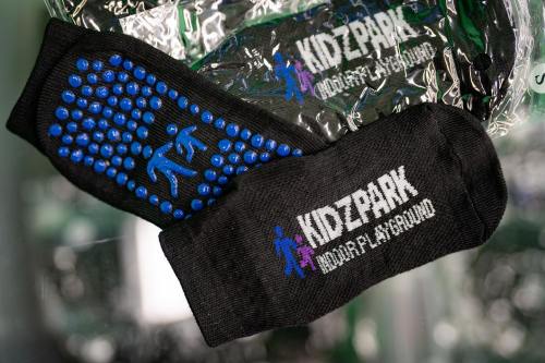 Black socks with blue grip dots and "KIDZPARK Indoor Playground" printed on them.