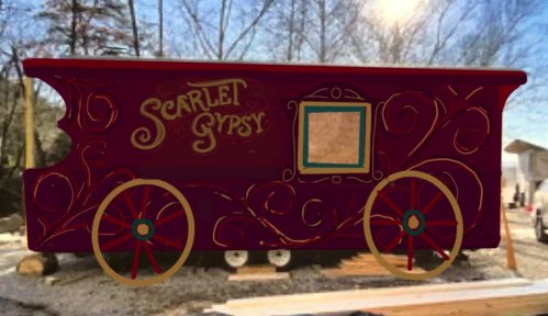 A vibrant red gypsy wagon with decorative swirls and the name "Scarlet Gypsy" painted on the side.