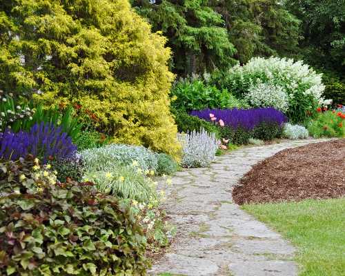 A vibrant garden path lined with colorful flowers and lush greenery, leading through a serene landscape.