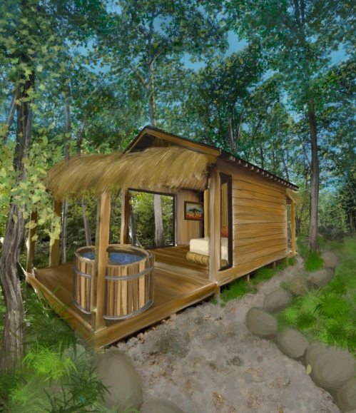 A cozy wooden cabin with a thatched roof, surrounded by trees, featuring a hot tub on a deck.