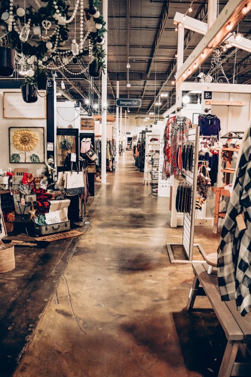 A spacious retail store aisle lined with various clothing and decor items on display.