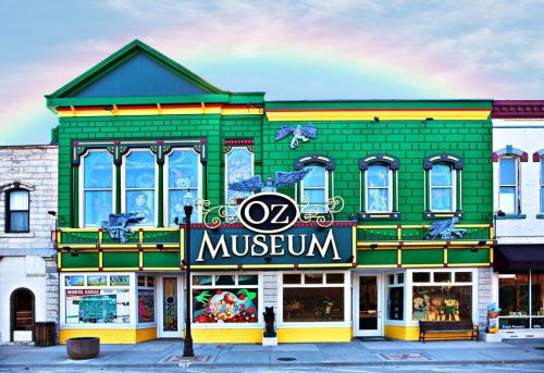 Colorful Oz Museum building with a rainbow in the background, featuring vibrant artwork and signage.