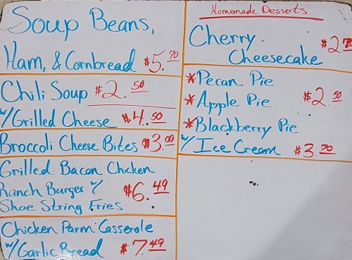 Menu board featuring soups, sandwiches, and desserts with prices listed in red and blue.