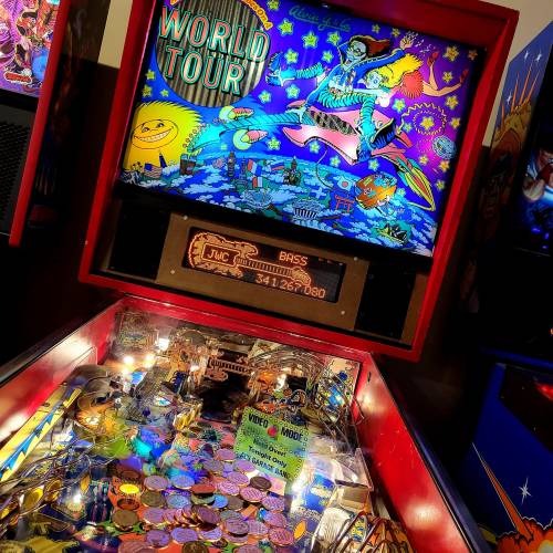 Colorful pinball machine featuring a vibrant "World Tour" theme with various characters and bright graphics.