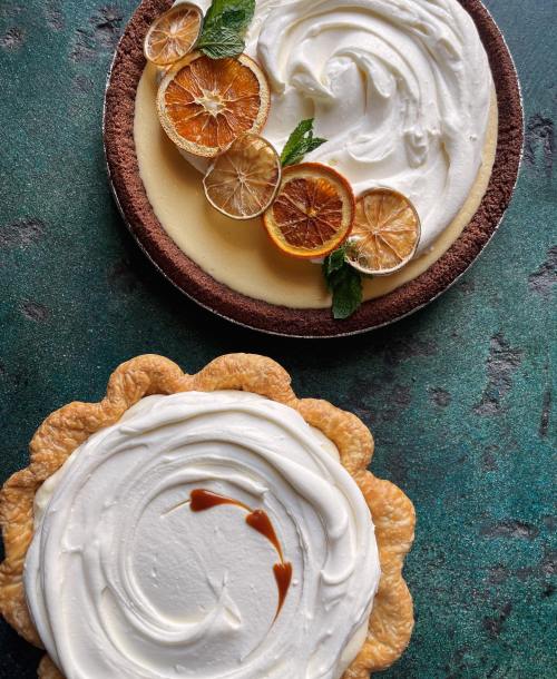 Two delicious pies: one with a creamy filling and dried orange slices, the other with a smooth white topping and caramel drizzle.