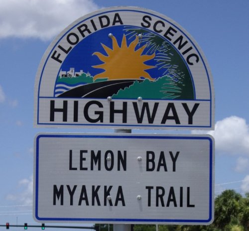 Sign for Florida Scenic Highway featuring a sun and text for Lemon Bay and Myakka Trail.