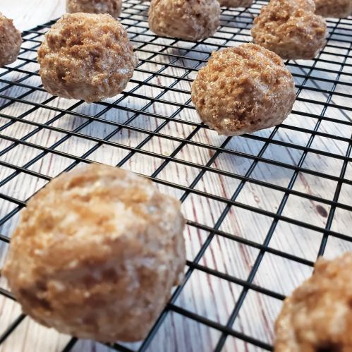 Freshly baked round cookies cooling on a wire rack, with a rustic wooden background.