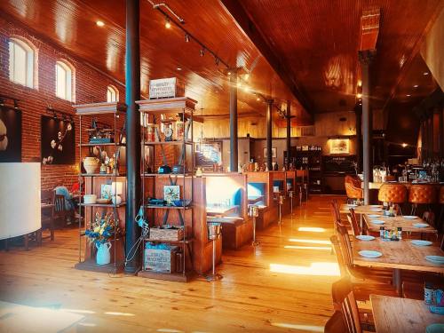 Brightly lit restaurant interior with wooden floors, cozy seating, and decorative shelves. Warm, inviting atmosphere.