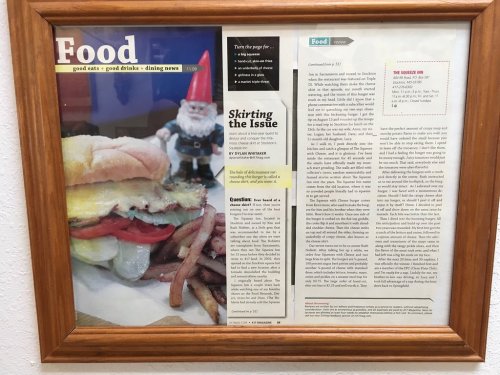 A framed article titled "Food" featuring a large sandwich, fries, and a gnome figurine beside it.