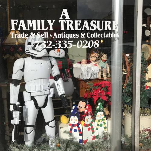 A storefront display featuring a Stormtrooper, snowmen, and various collectibles for sale.