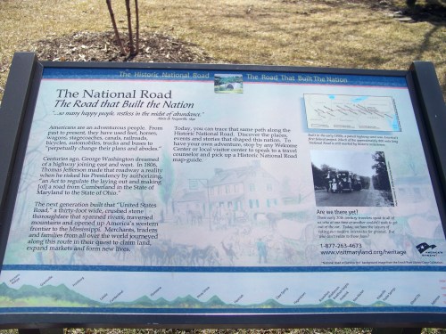 Sign about the National Road, highlighting its historical significance and inviting visitors to explore its heritage.