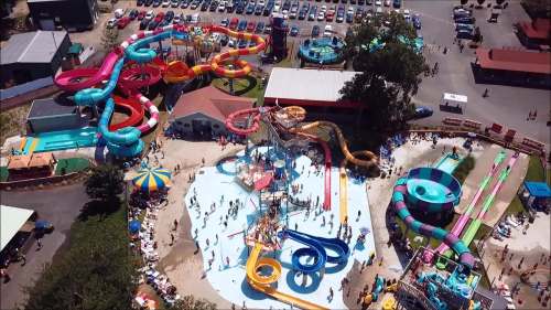 Aerial view of a vibrant water park with colorful slides, pools, and people enjoying the attractions.