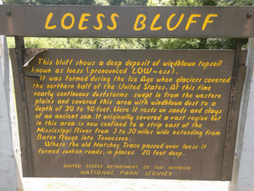 Sign describing Loess Bluff, its formation, and geological features, located in a natural setting.