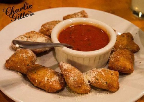 Plate of fried appetizers arranged around a bowl of marinara sauce, topped with grated cheese.