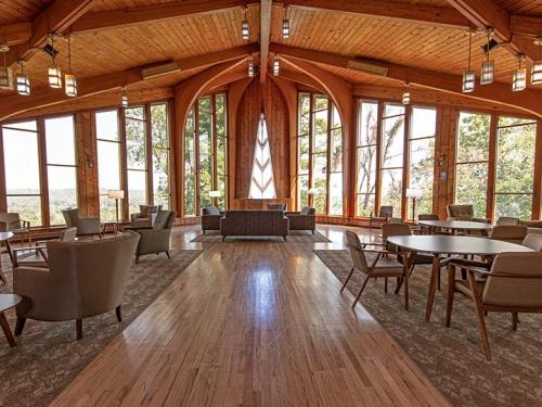 A spacious, wooden interior with large windows, comfortable seating, and a scenic view of nature outside.