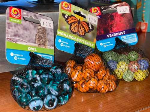 Four bags of marbles in netting, labeled "Owl," "Monarch Butterfly," and "Stardust," priced at $3.99 each.