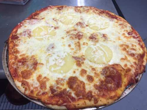 A freshly baked pizza topped with melted cheese and pineapple slices on a golden crust.