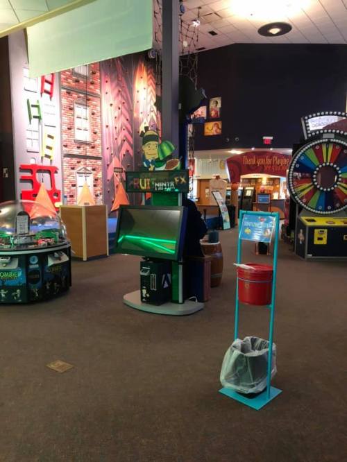 A colorful indoor play area featuring games, a prize wheel, and interactive exhibits.