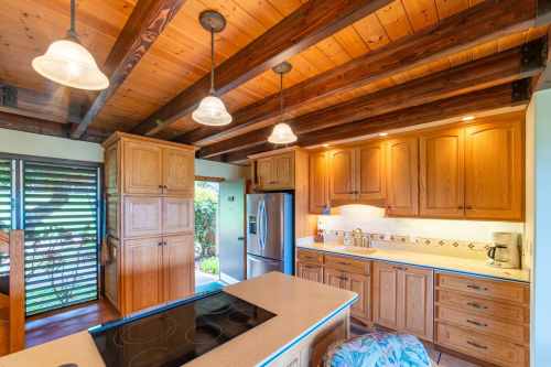 A warm, wooden kitchen with a central island, modern appliances, and pendant lighting, featuring a cozy, inviting atmosphere.