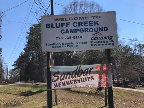 Sign for Bluff Creek Campground, featuring details about camping, fishing, swimming, and sandbar memberships.