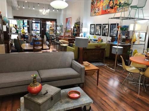 A stylish interior featuring a mix of vintage furniture, colorful decor, and art in a cozy, well-lit space.