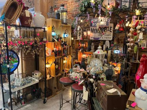 A cozy shop filled with vintage items, decor, and handmade crafts displayed on shelves and tables.