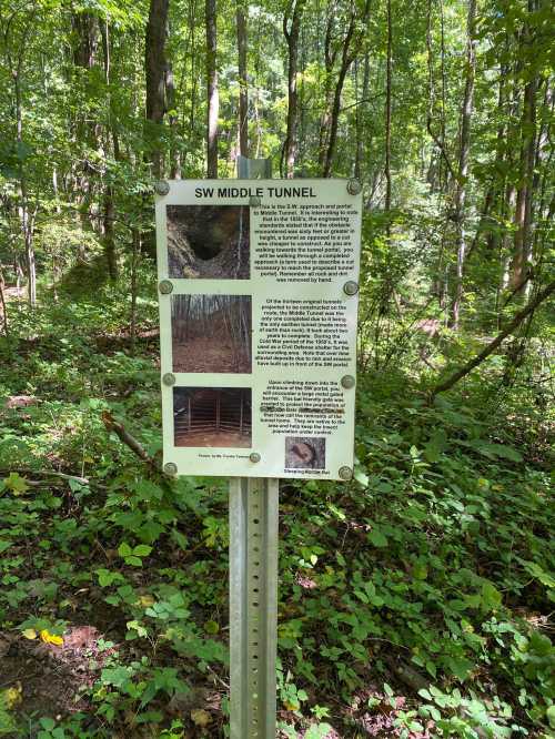 Sign about the SW Middle Tunnel in a wooded area, featuring text and images related to the tunnel's history and features.