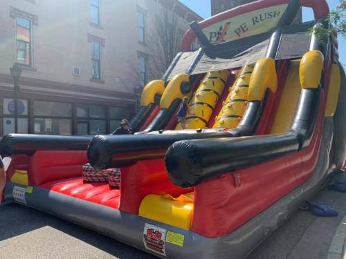 A large inflatable slide and obstacle course set up outdoors, featuring bright colors and a fun design.