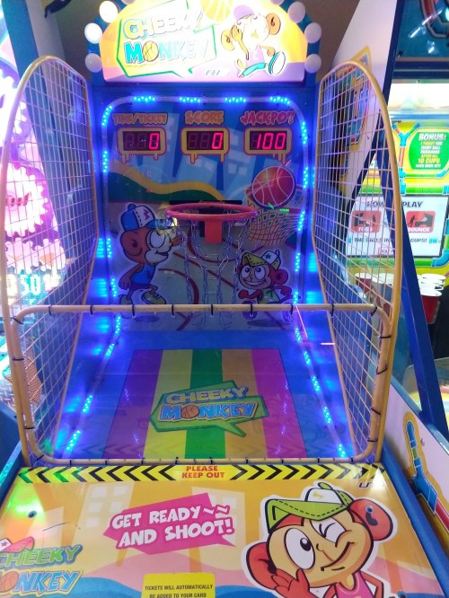 A colorful arcade basketball game called "Cheeky Monkey," featuring bright lights and a playful design.