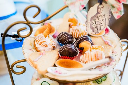 A tiered stand filled with assorted pastries, including cream-filled treats and chocolate-covered confections.
