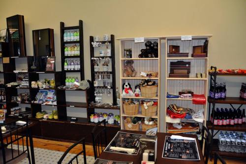 A cozy shop interior featuring shelves of various products, including drinks, snacks, and souvenirs.