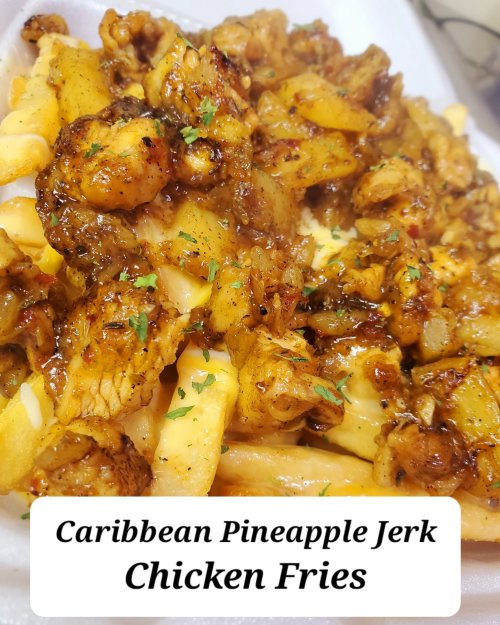 A close-up of Caribbean pineapple jerk chicken fries, featuring seasoned chicken and fries topped with herbs.