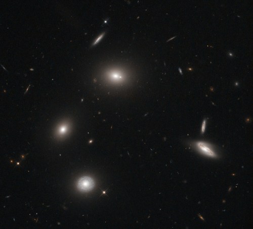 A stunning view of distant galaxies and stars in a dark cosmic background, showcasing various shapes and brightness.