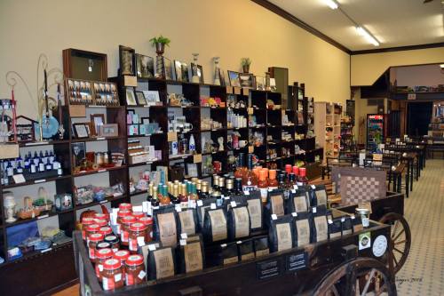 A cozy shop interior with shelves displaying various products, including jars, bottles, and decorative items.