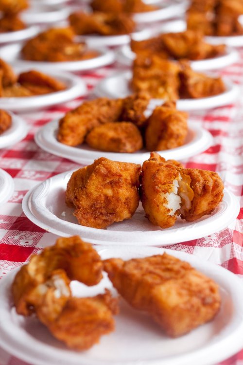 Plates of golden-brown fried food arranged on a checkered tablecloth.