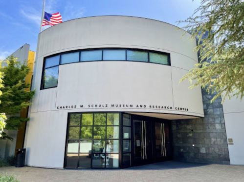 Entrance of the Charles M. Schulz Museum and Research Center, featuring a modern design and an American flag.