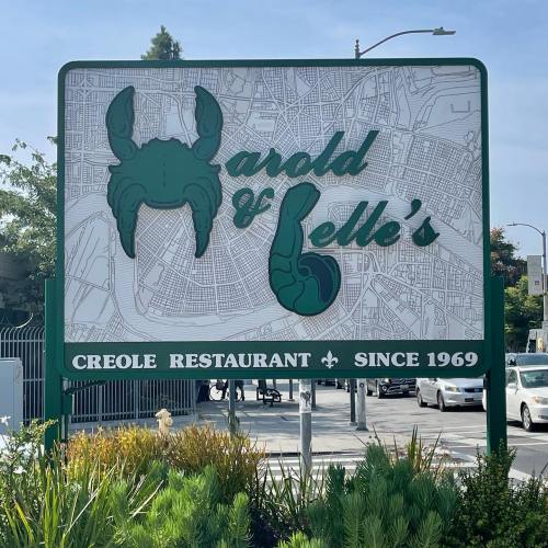 Sign for Harold & Belle's Creole Restaurant, featuring a crab and a raised hand, established in 1969.