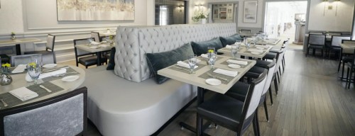 Modern restaurant interior featuring elegant seating, neatly arranged tables, and soft lighting.