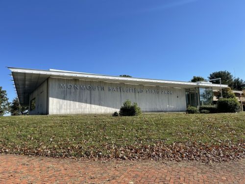 Modern building of Monmouth Battlefield State Park, set against a clear blue sky and grassy landscape.