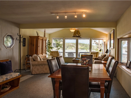 Cozy living area with a dining table, comfortable seating, and large windows overlooking a scenic view.