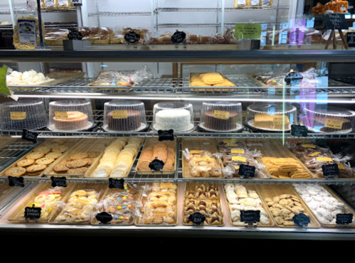 A display case filled with various baked goods, including cakes, cookies, and pastries, all neatly arranged.