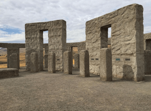 A stone structure resembling Stonehenge, with tall pillars and a cloudy sky in the background.