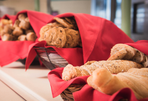 Baskets of assorted baked goods, including cookies and bread, draped with red cloth.